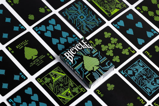 Bicycle playing cards with green and blue designs on a black background