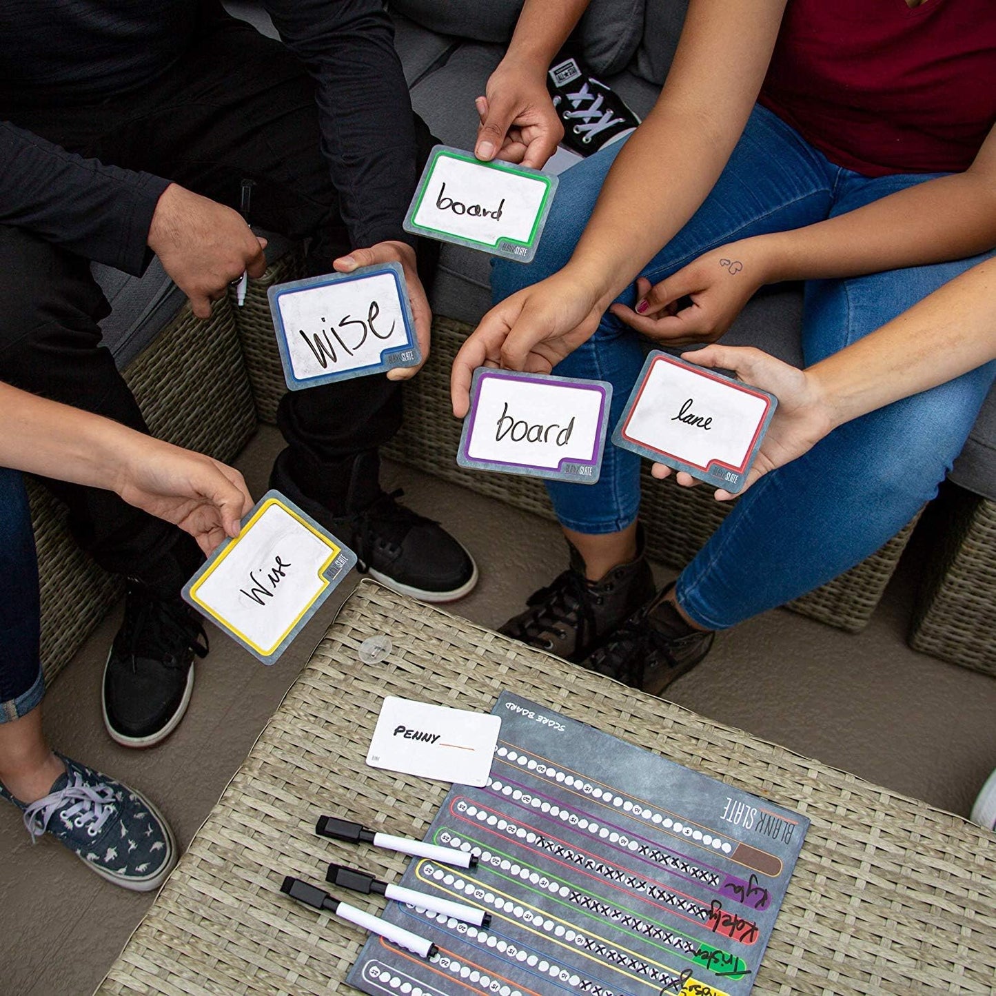 Group of people holding Blank Slate cards with words on them, sitting around a table.