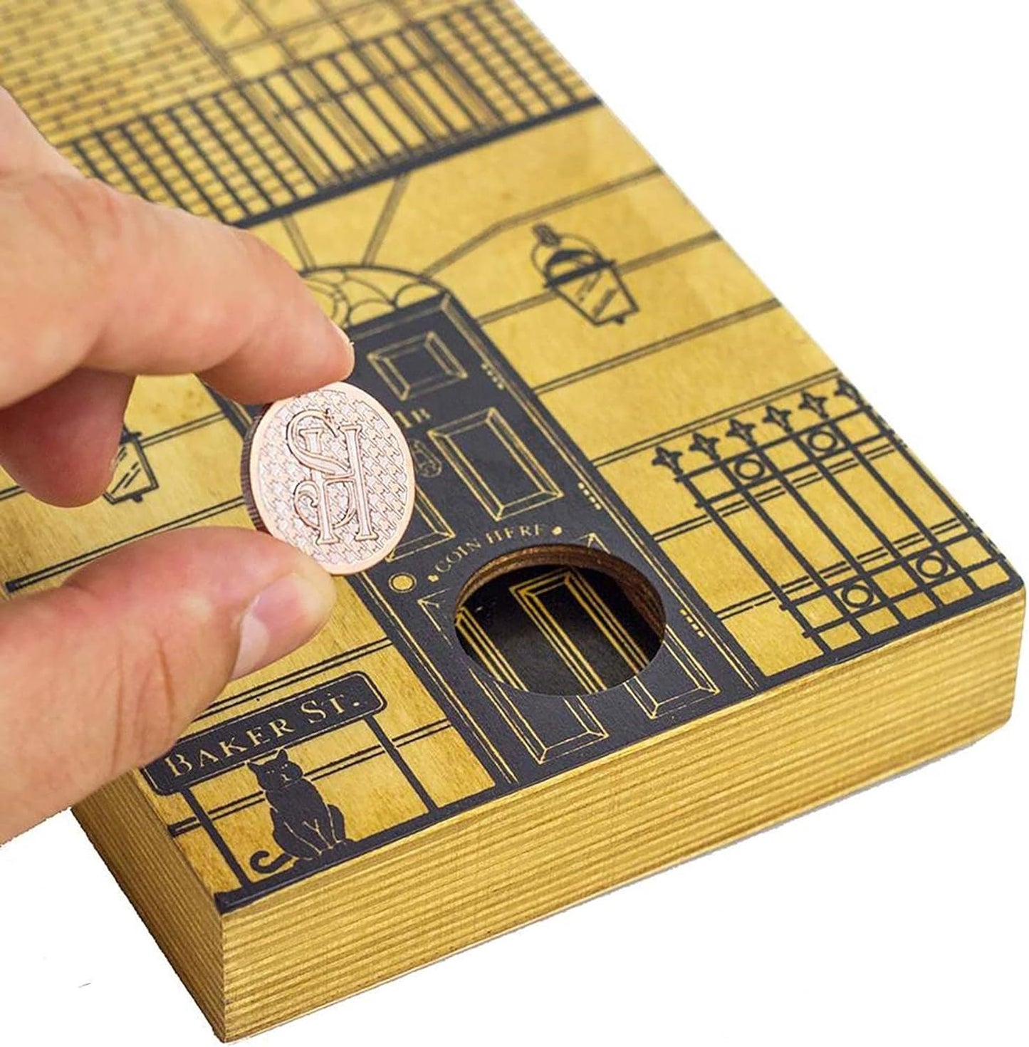 Hand holding a coin above a gold and black box with architectural design