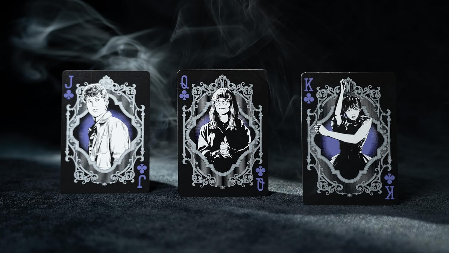 Three playing card figures with intricate designs on a dark background