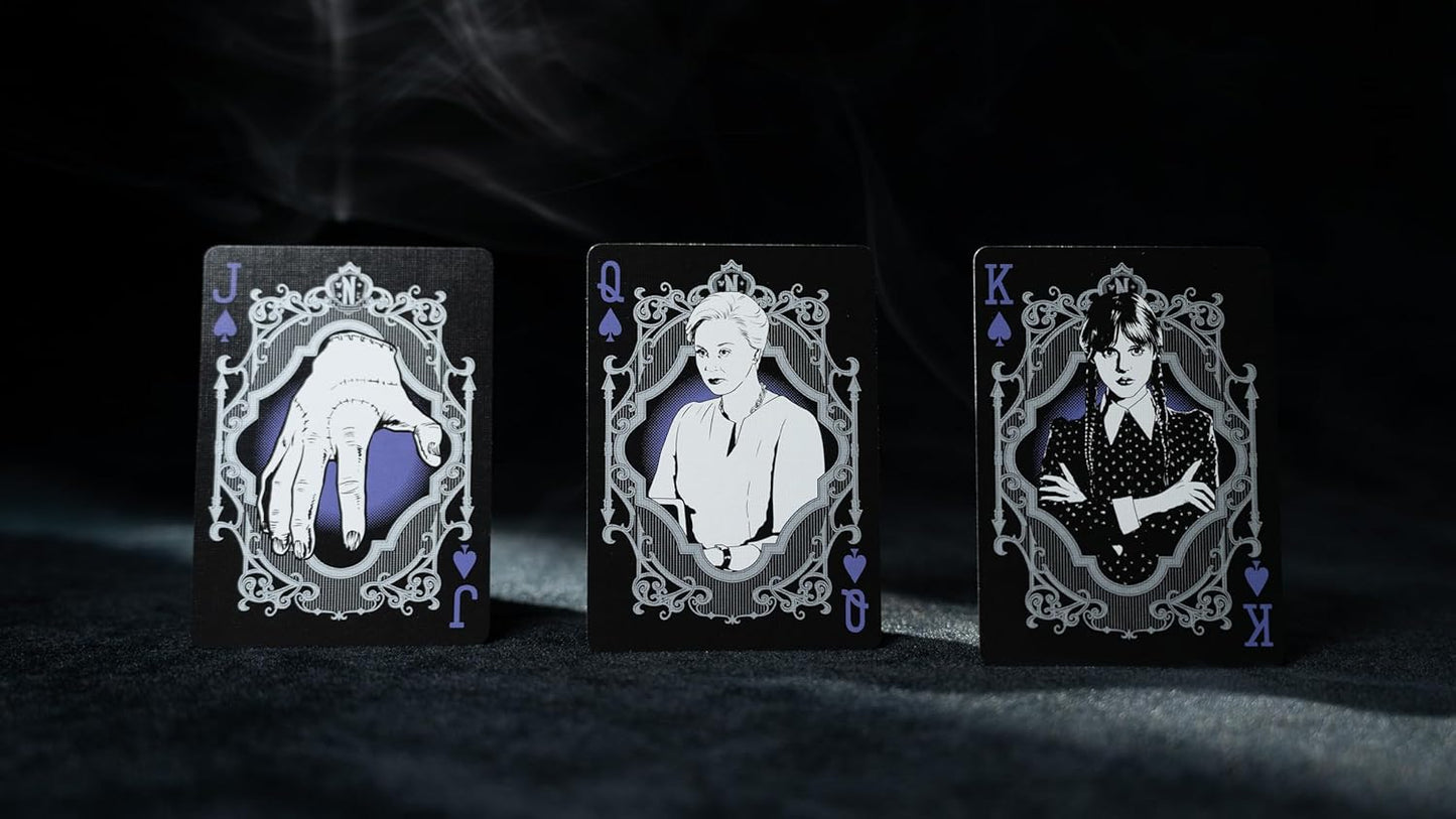 Three playing cards with decorative frames and portraits on a dark background