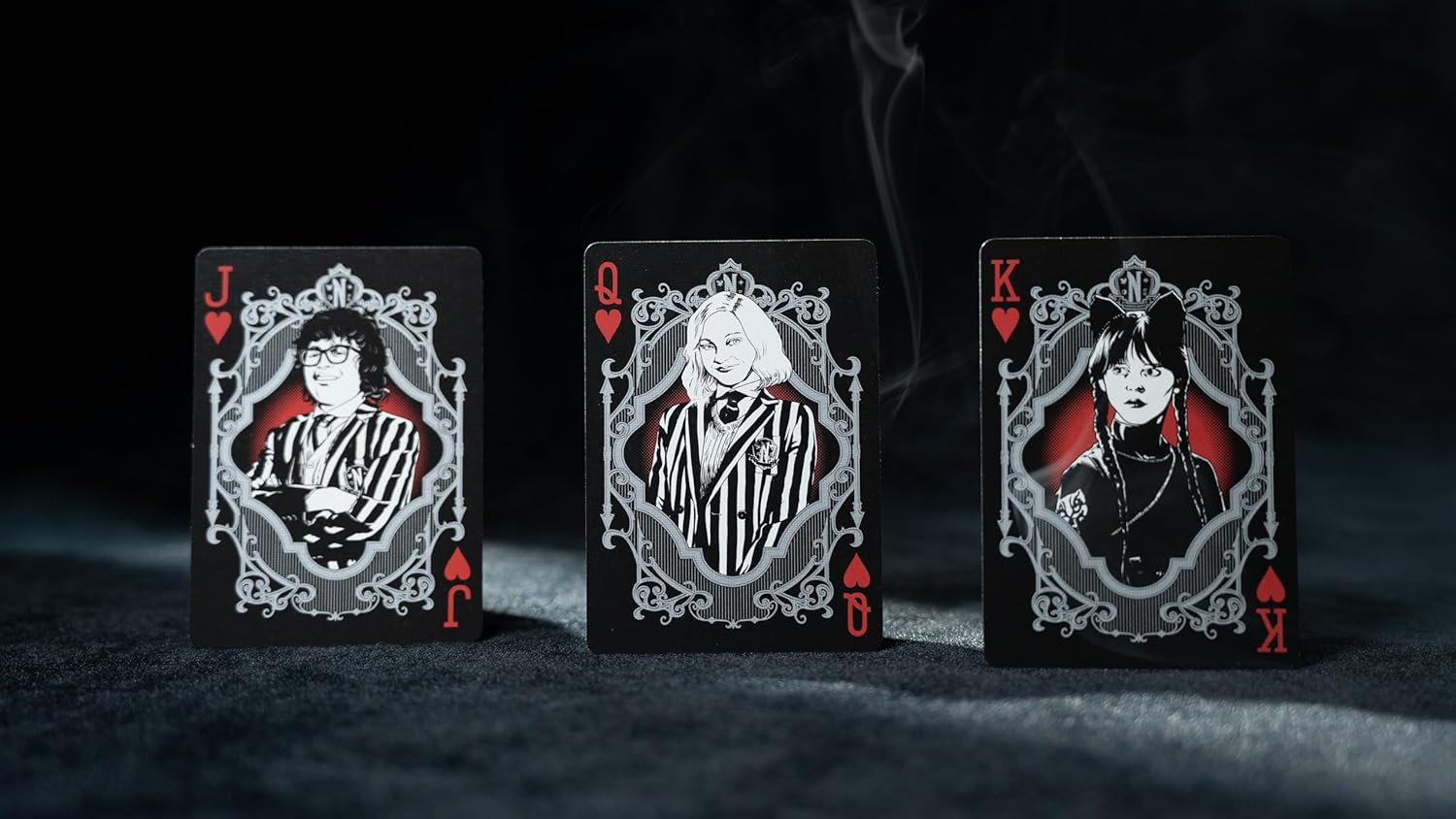 Three playing cards with character illustrations on a dark background