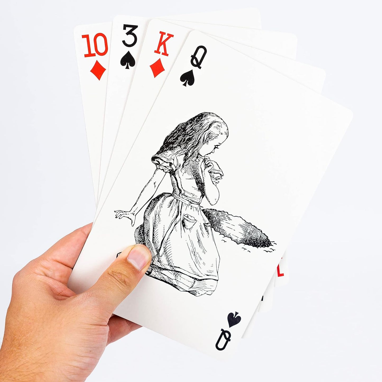 Playing cards with Alice in Wonderland design held by a hand on a white background
