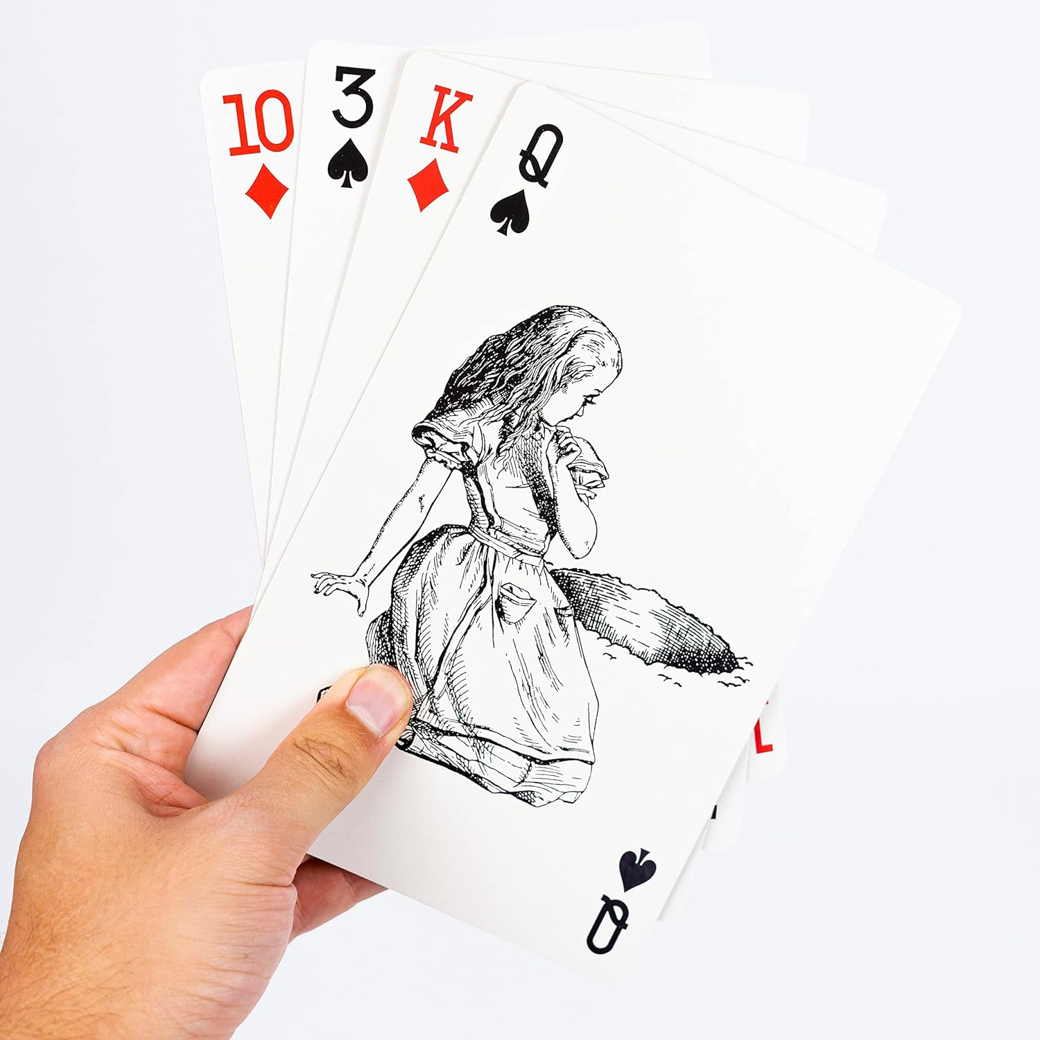 Playing cards with Alice in Wonderland design held by a hand on a white background