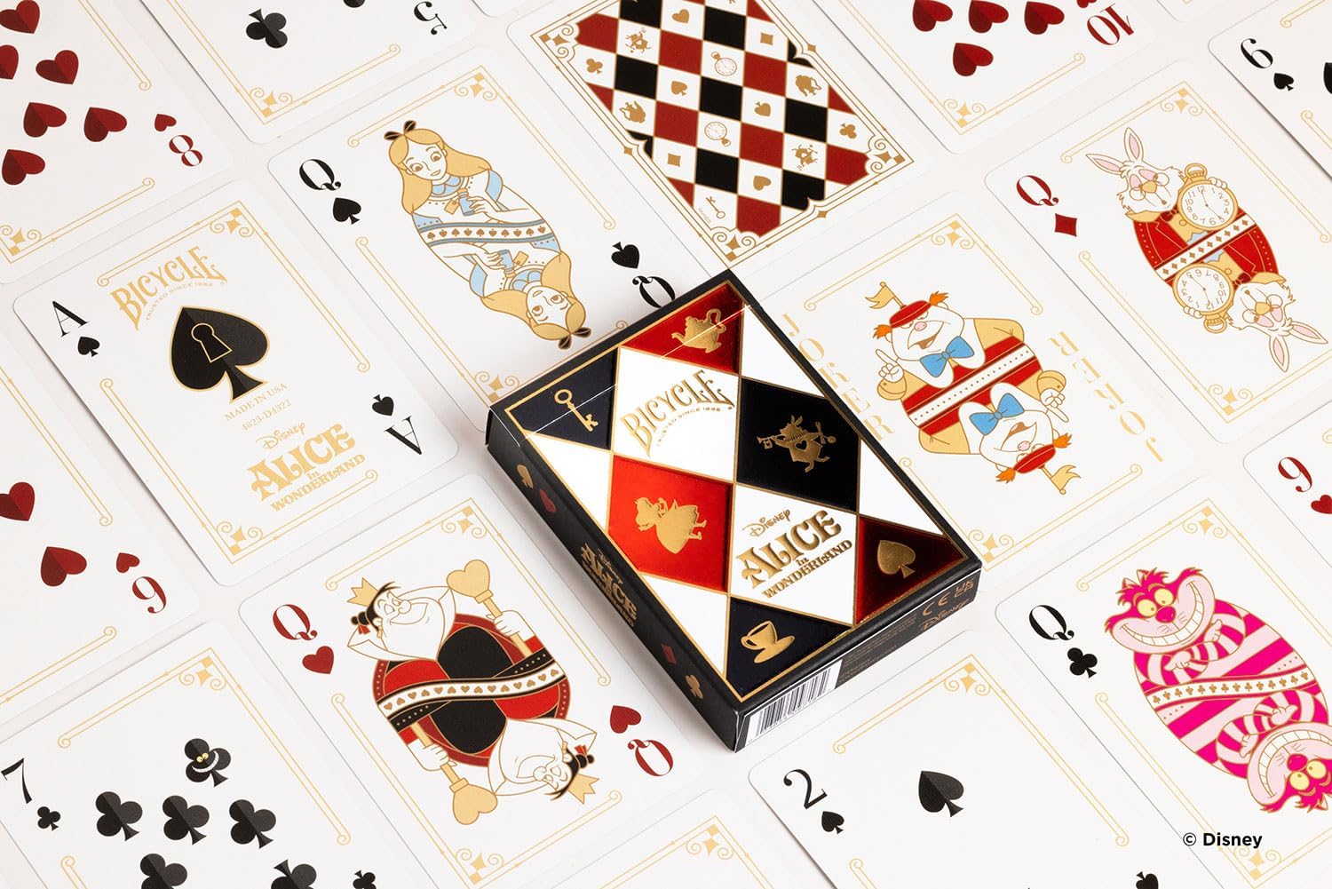 Playing cards with Alice in Wonderland design and a deck box on top