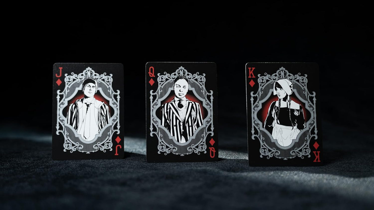 Three playing cards with decorative designs on a dark background