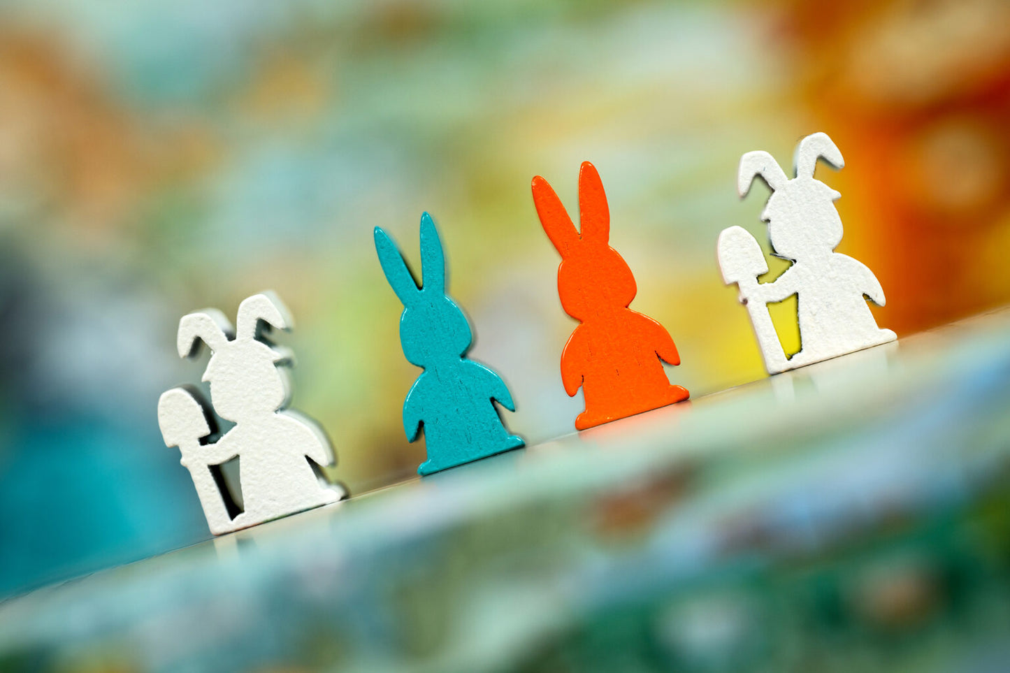 Colourful wooden rabbit figurines for Bunny Kingdom Town on a blurred background
