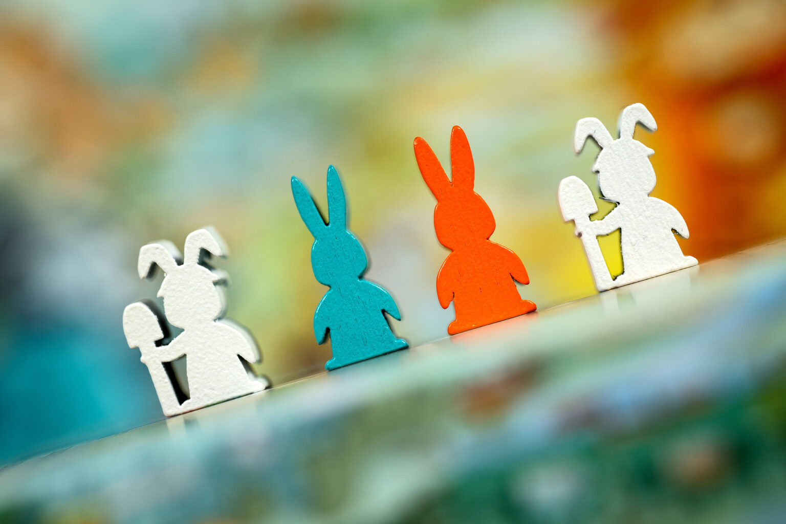 Colourful wooden rabbit figurines for Bunny Kingdom Town on a blurred background