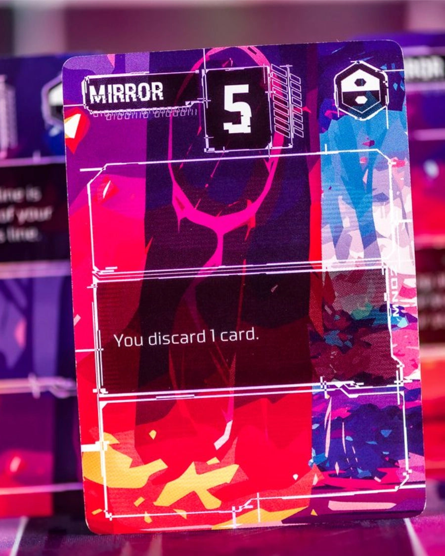Complie: Main 2 Card game close-up, featuring the text 'MIRROR' and 'You discard 1 card.' with abstract neon paint splatter graphics in red, pink, purple, blue, and yellow.