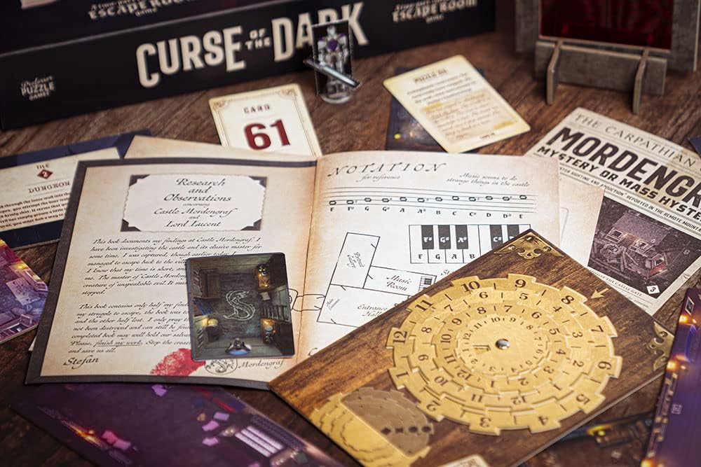 Curse of The Dark contents laid out on a wooden table