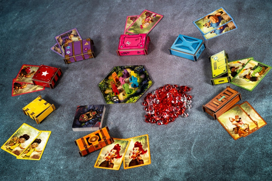 Collection of colourful game cards and containers on a textured surface with red gemstones for Diamant board game.