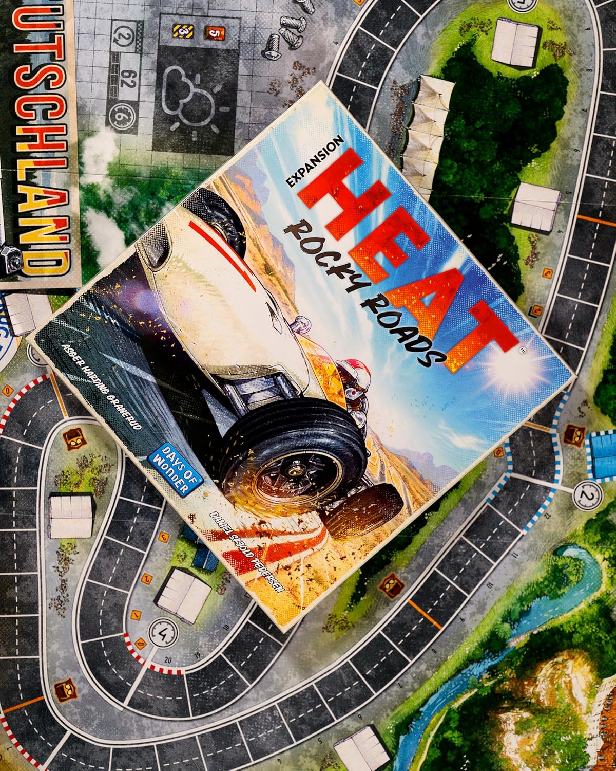 Heat Rocky Roads board game expansion pack for 'HEAT' pedal to the metal on a game board with roads and landscapes.