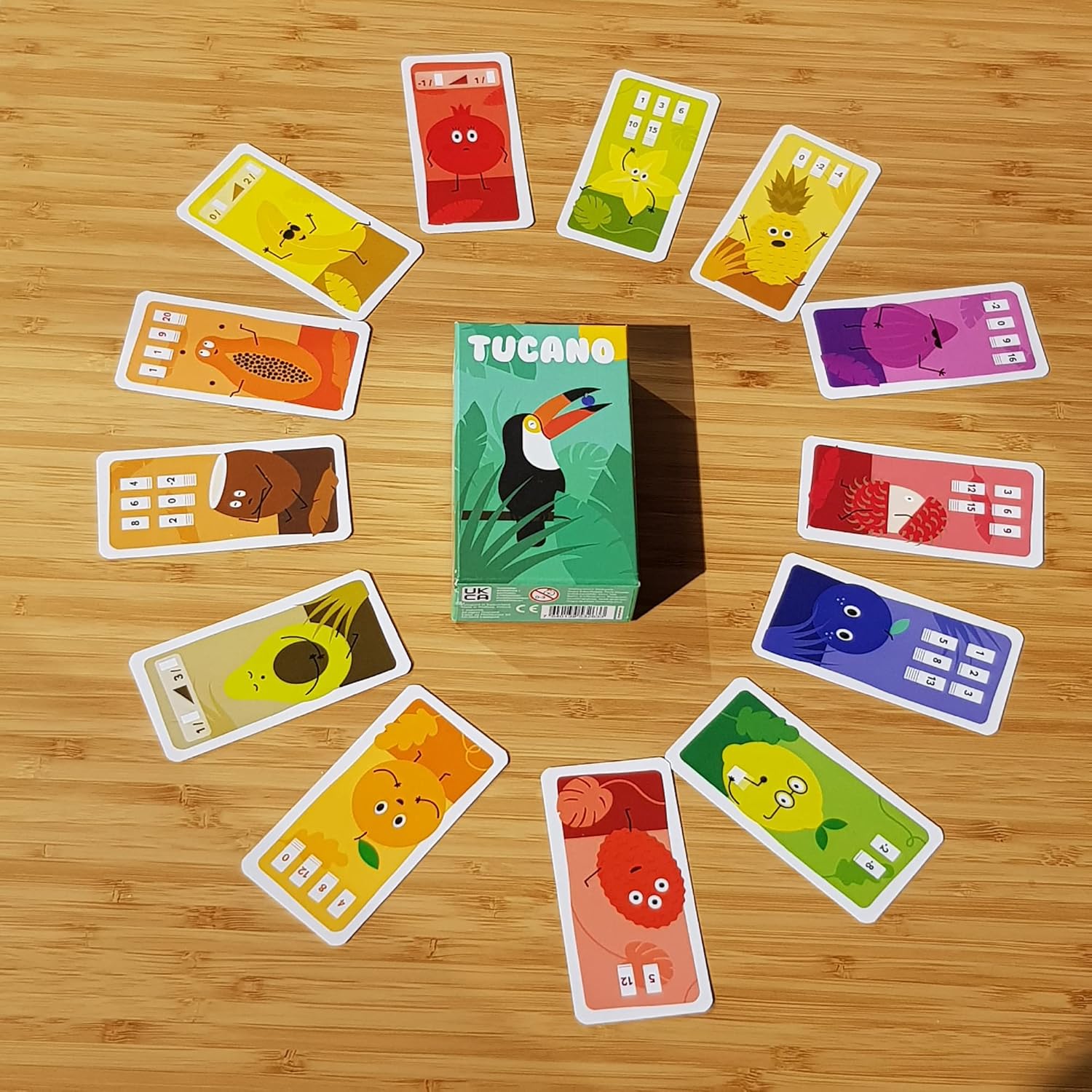 Card game with colourful cards and a central box on a wooden surface