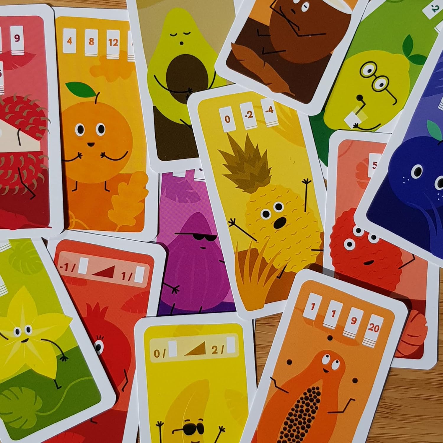 Colourful card game cards with cartoonish designs on a wooden surface