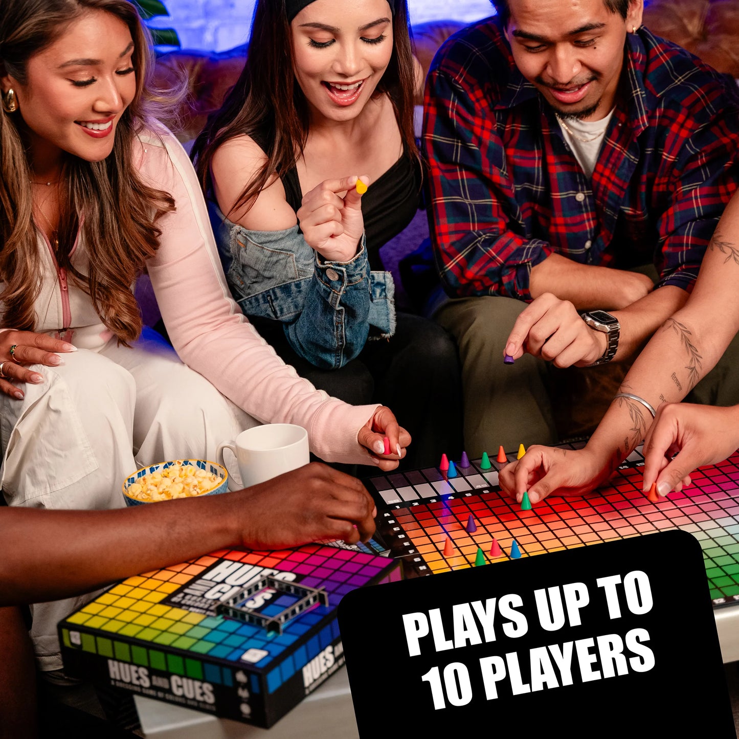 Four friends playing Hues and Cues game together, with text indicating it plays up to 10 players.