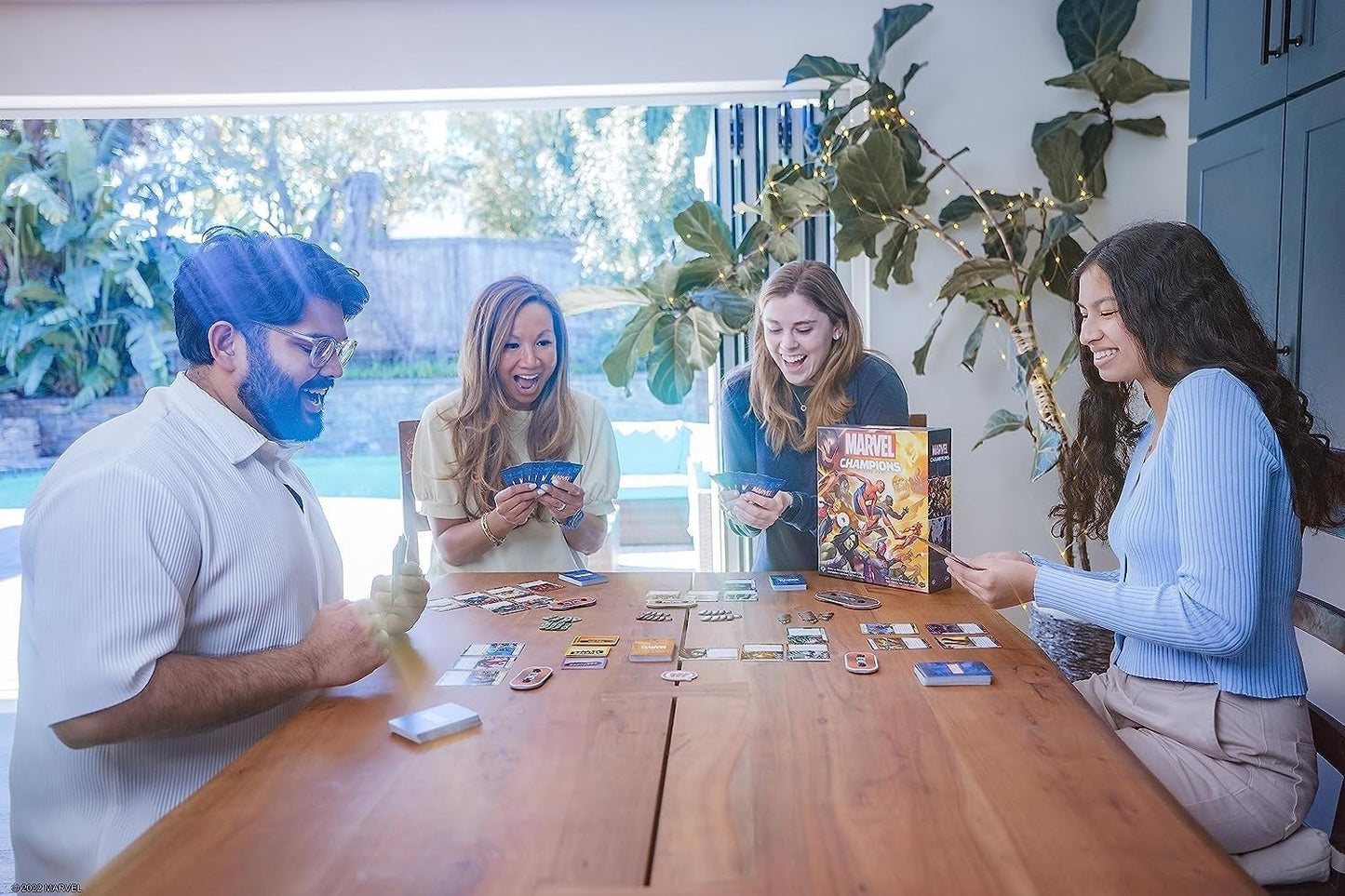 Four people playing Marvel Champions - The Card Game together at a table.