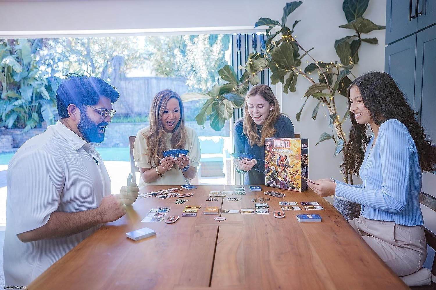 Four people playing Marvel Champions - The Card Game together at a table.