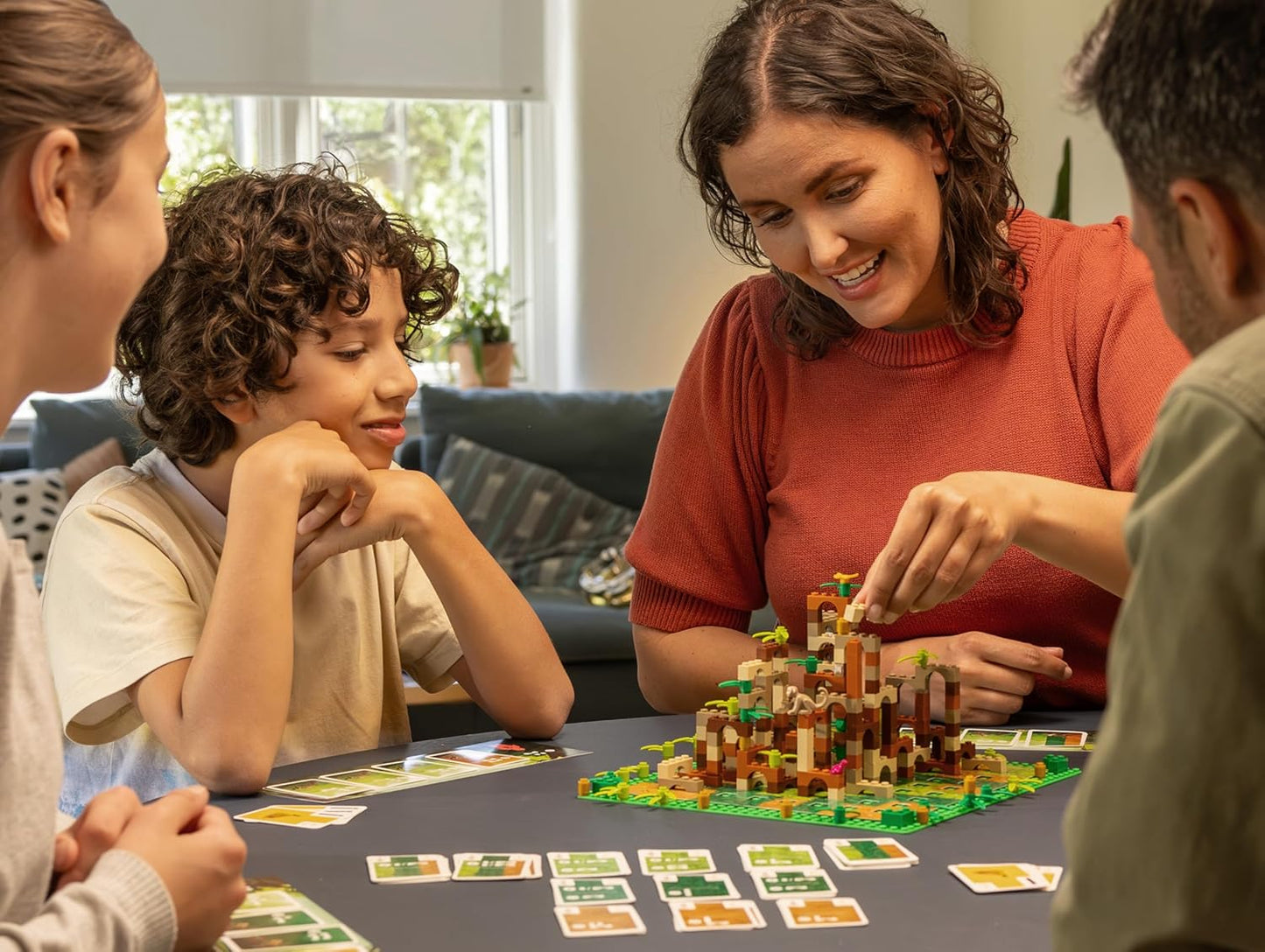Family playing the Monkey Palace board game together in a cosy living room.