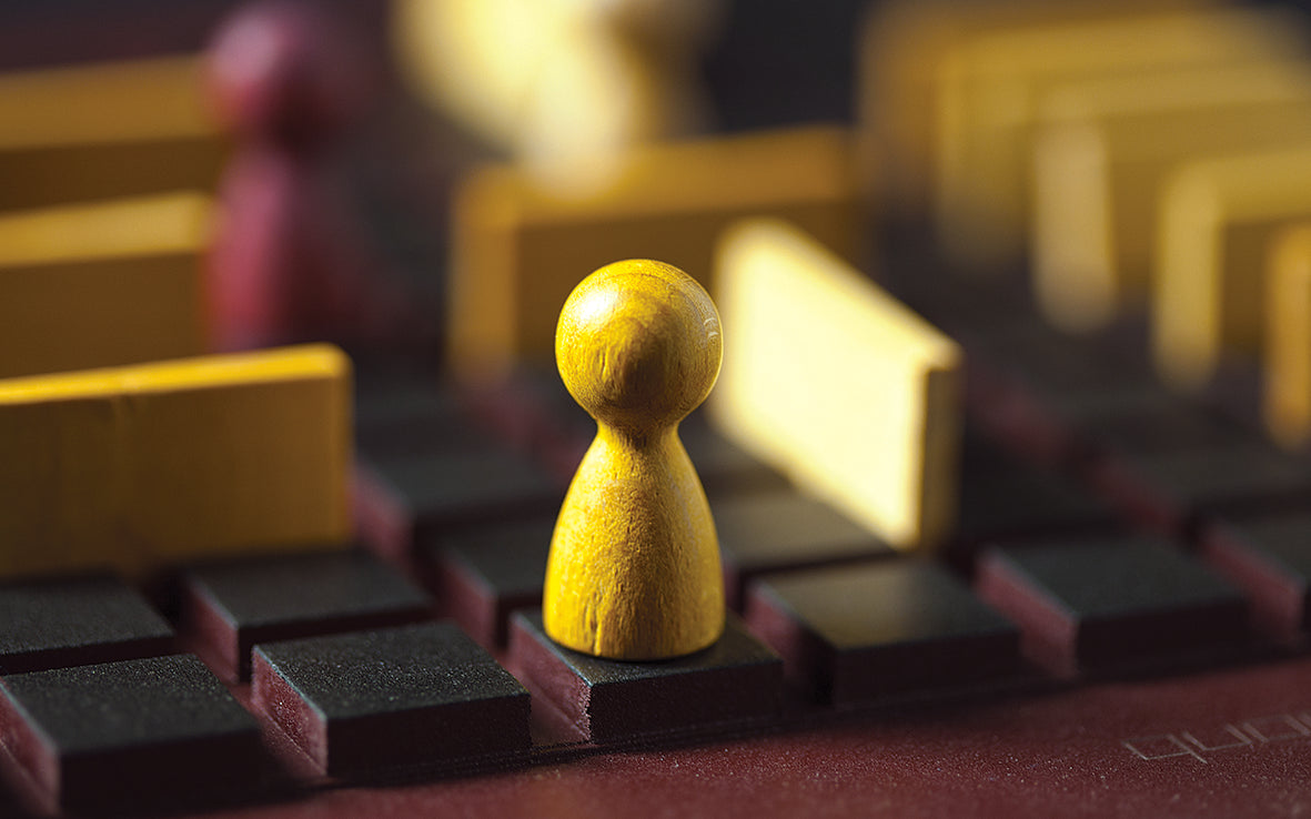 Close-up of a wooden game piece on a board with blurred background