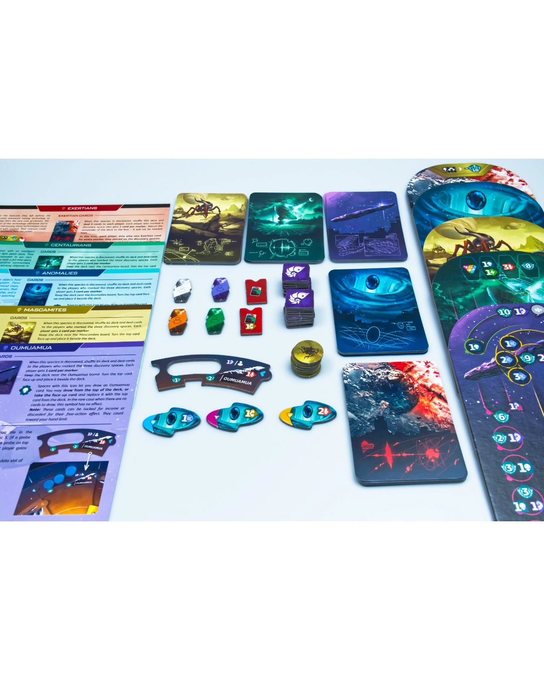 SETI: search for extraterrestrial intelligence with illustrated cards, tokens, dice, and instruction sheets arranged on a white surface. The components feature dark sci-fi artwork in blue, purple, green, and red tones.