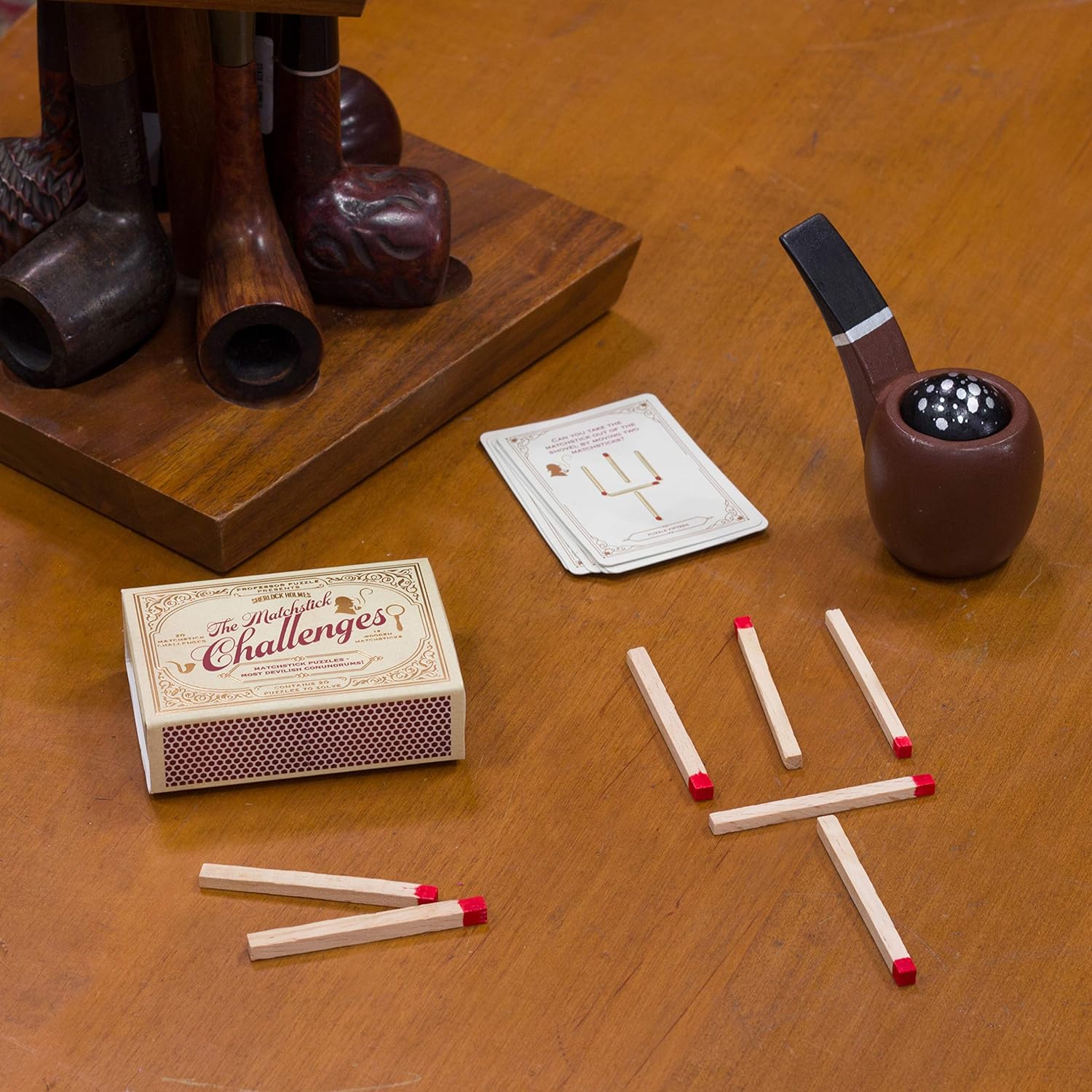 Matchbox, matches, card, and smoking pipe on a wooden surface