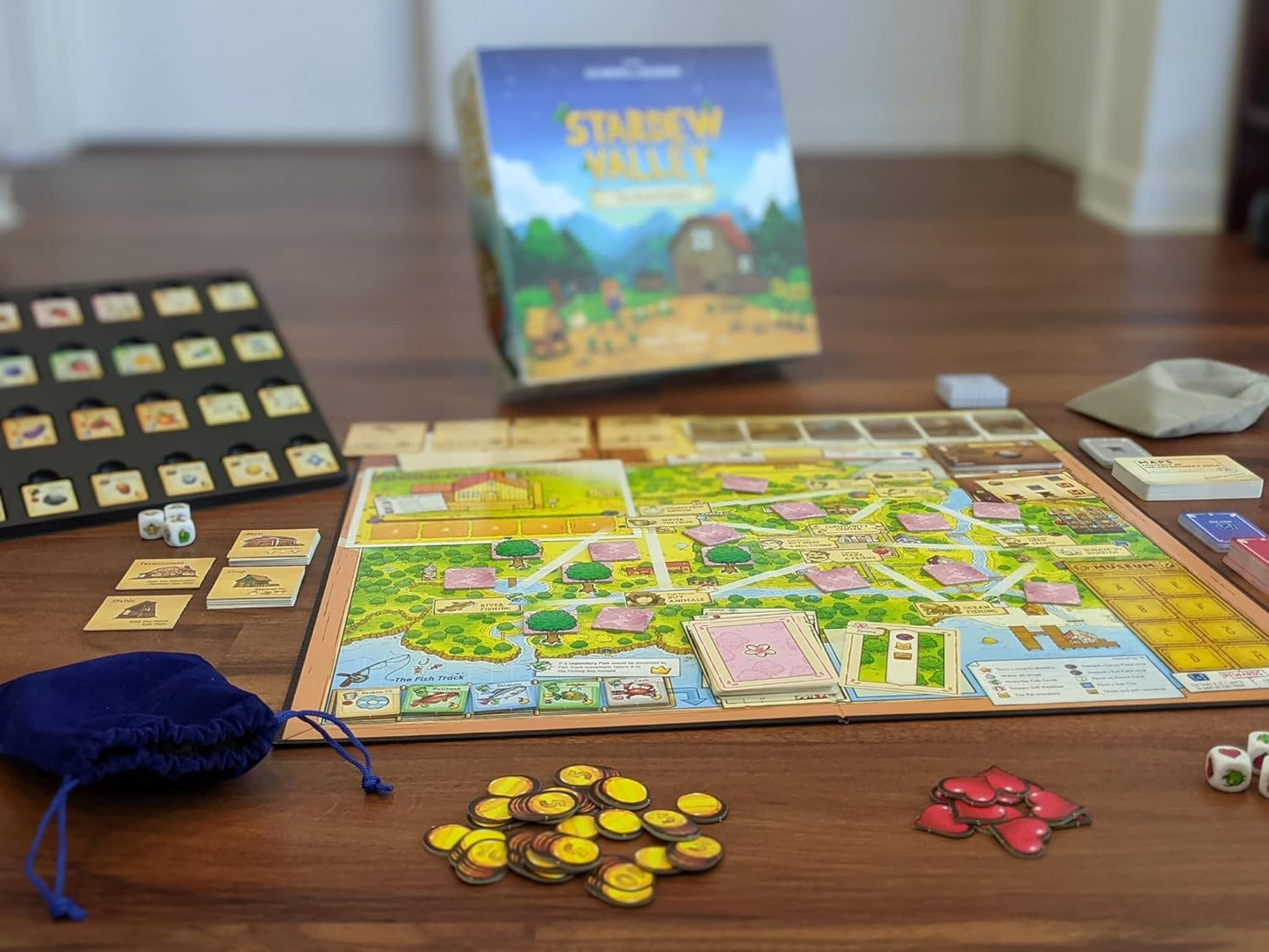 Cooperative board game setup with 'Stardew Valley' board game box in the background