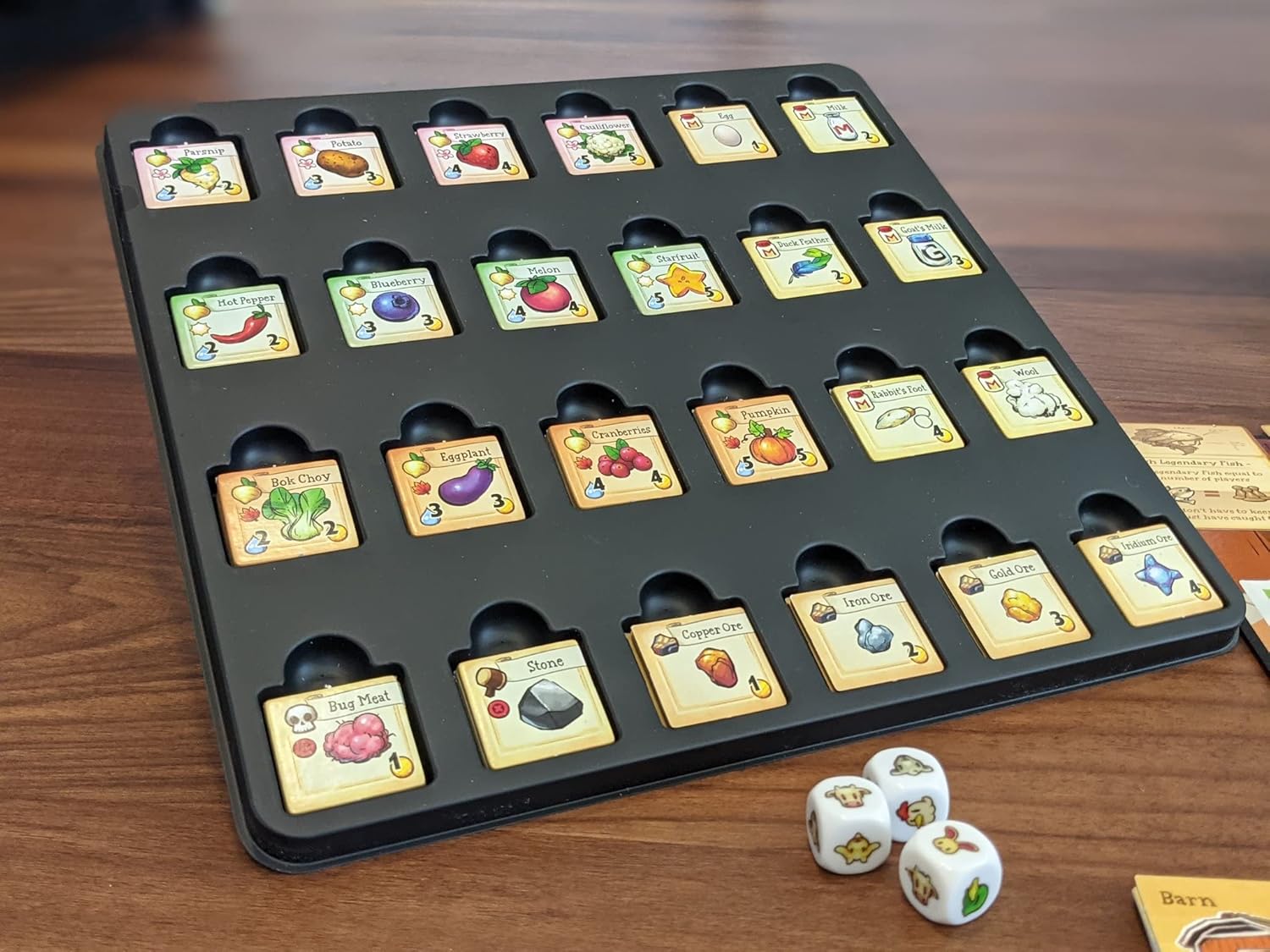 Board game tray with cards and dice on a wooden surface for Stardew Cooperative farming board game