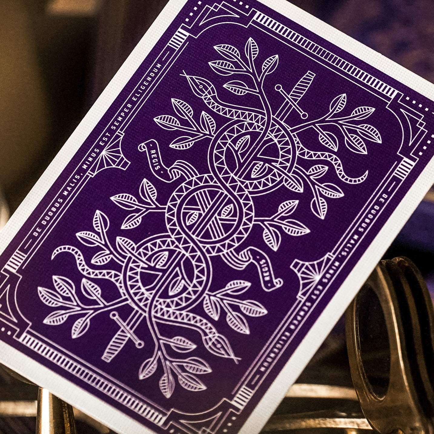 Purple playing card with white intricate design on a dark background
