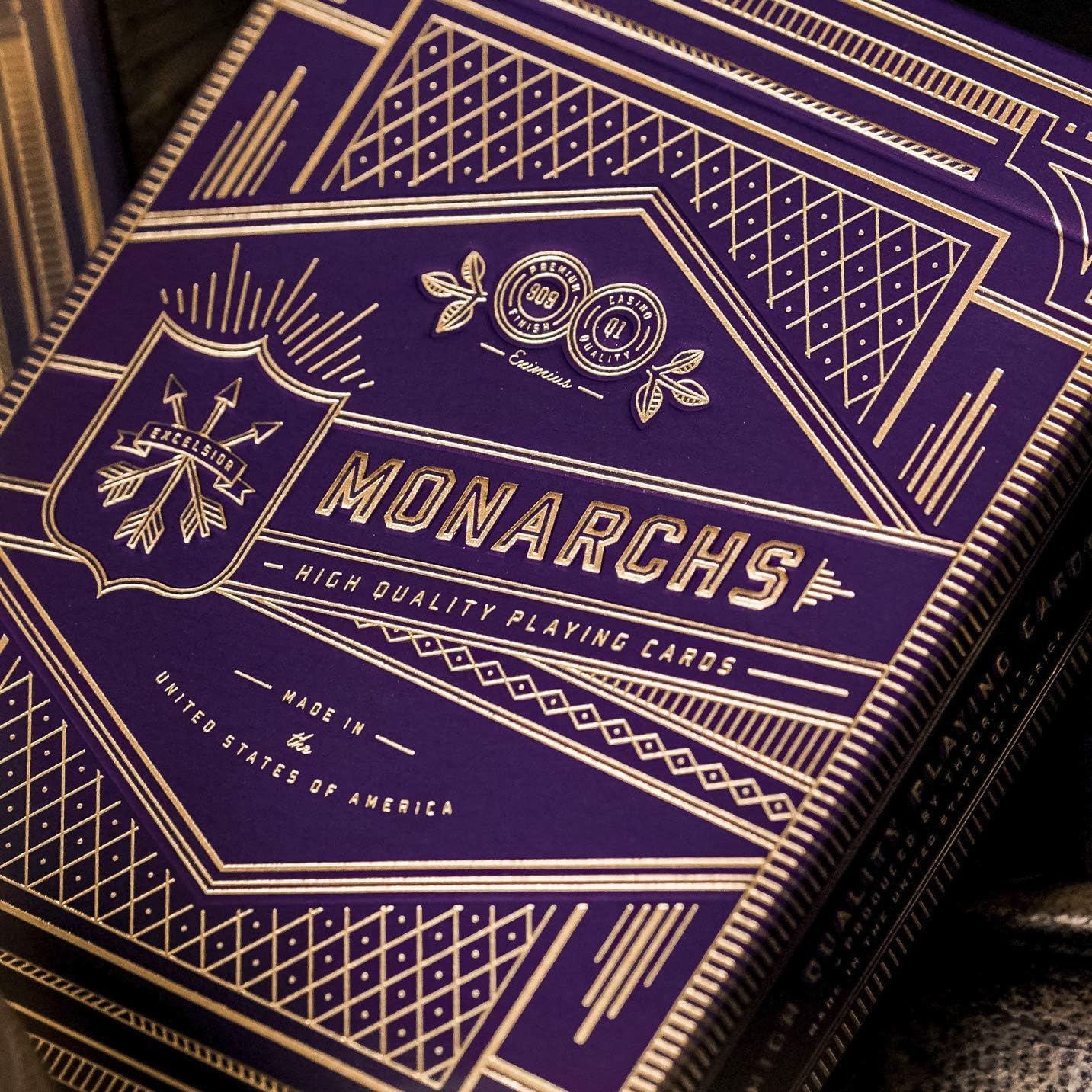 Close-up of a deck of Monarchs playing cards with gold text on a purple background.