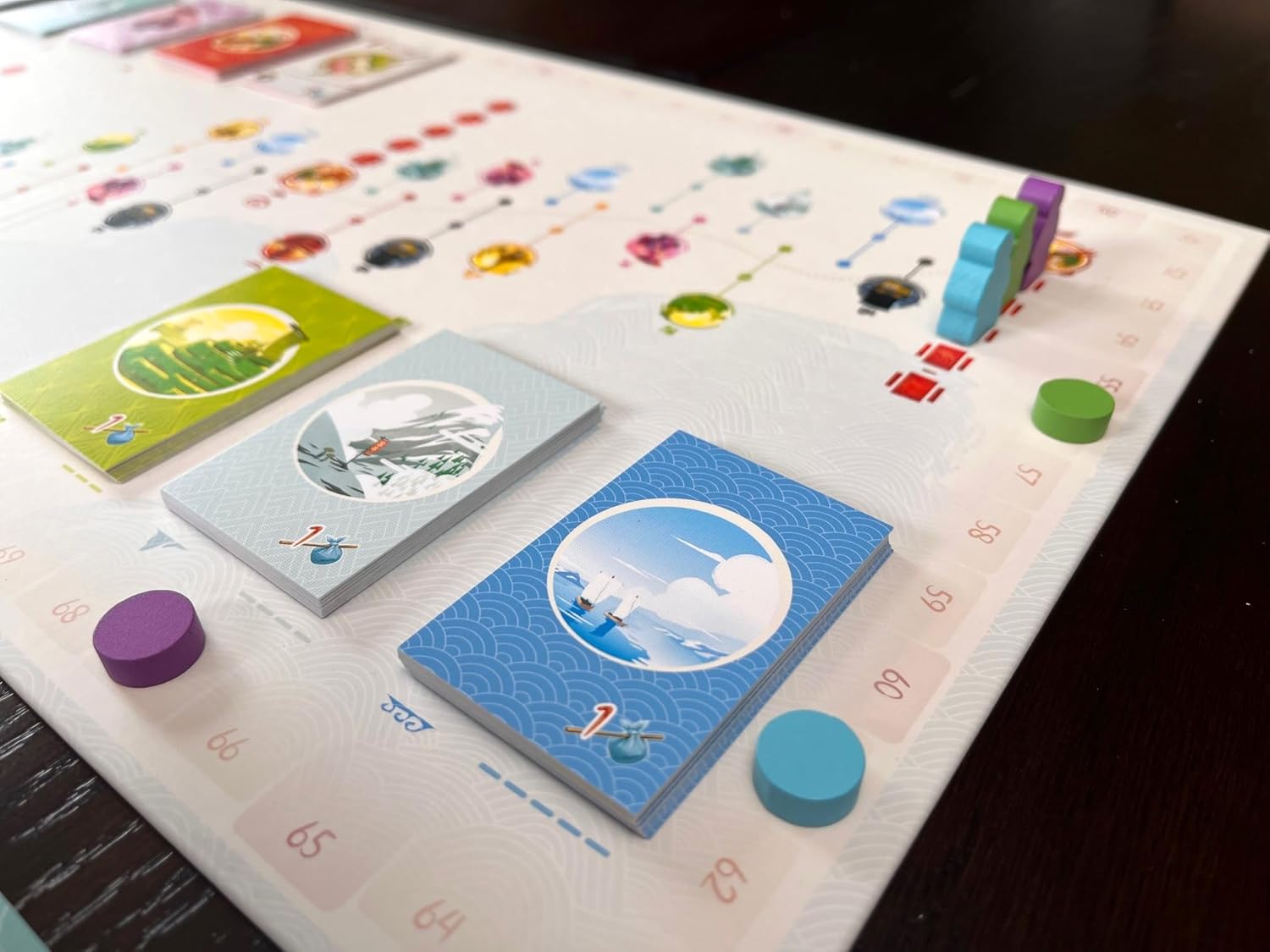 Board game with cards and colorful pieces on a white board