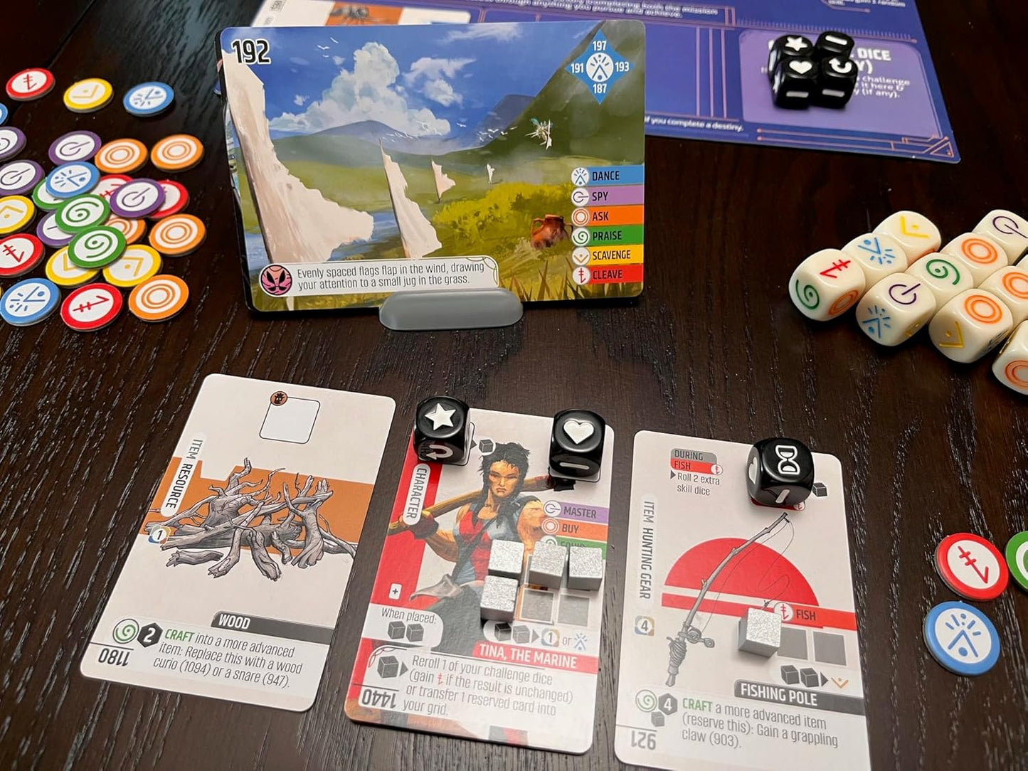 Vantage board game components including cards, dice, and tokens on a wooden surface