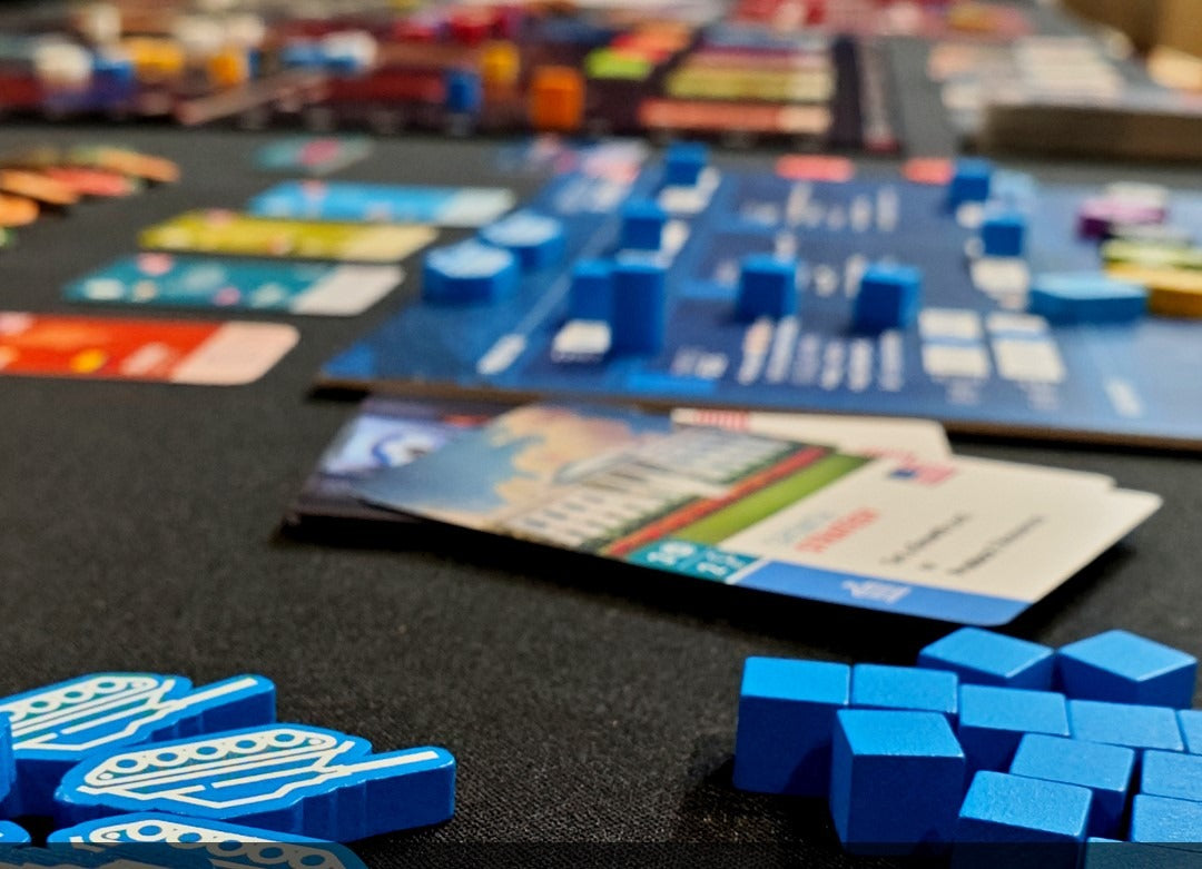 World Order board game box by Hegemonic Project Games Close-up of a board game with blue game pieces and cards on a black surface